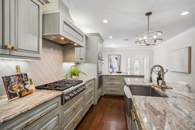 1114 W Cottage St, Houston, TX 77009 - kitchen with stainless steel appliances, custom exhaust hood, gray cabinets, ornamental molding, and dark wood-style floors