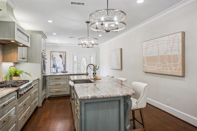 1114 W Cottage St, Houston, TX 77009 - kitchen with appliances with stainless steel finishes, gray cabinetry, crown molding, custom range hood, and a chandelier