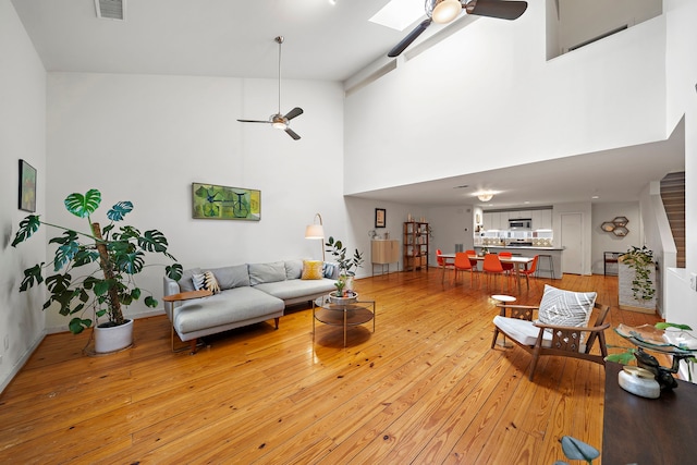1821 Tuam St, Houston, TX 77004 - living area featuring a ceiling fan, light wood finished floors, and a towering ceiling