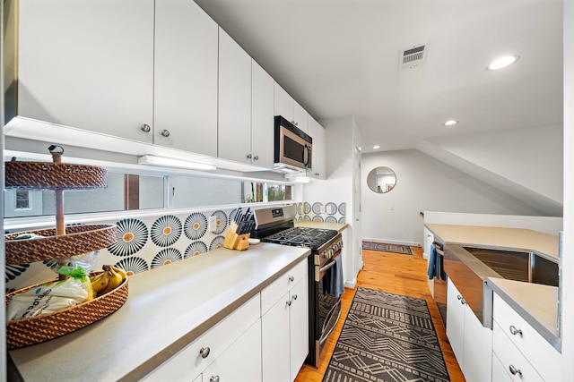 1821 Tuam St, Houston, TX 77004 - kitchen with appliances with stainless steel finishes, light wood-type flooring, recessed lighting, white cabinets, and light countertops