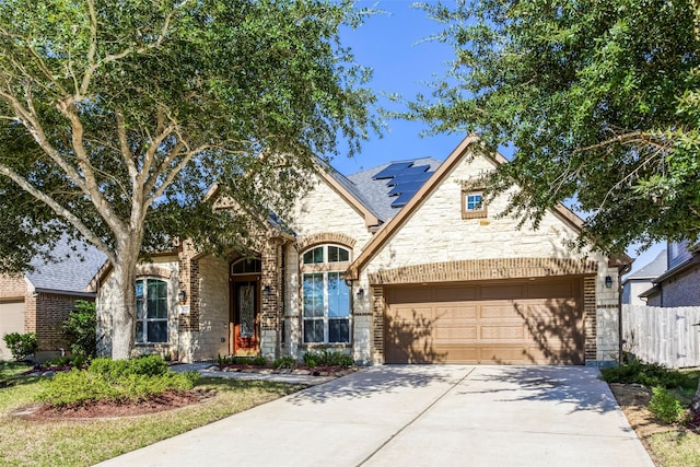 29114 Davenport Dr, Katy, TX 77494 - view of front of house featuring stone siding, concrete driveway, solar panels, and an attached garage