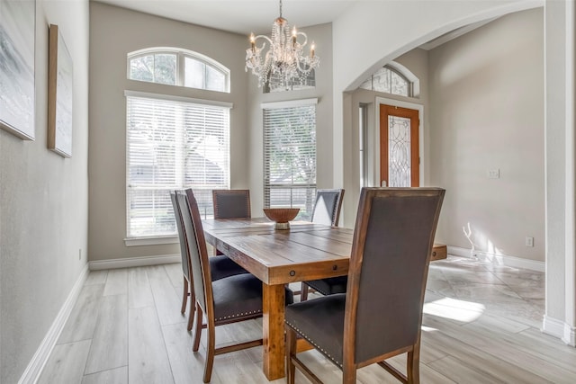 29114 Davenport Dr, Katy, TX 77494 - dining space with arched walkways, a chandelier, and light wood-type flooring