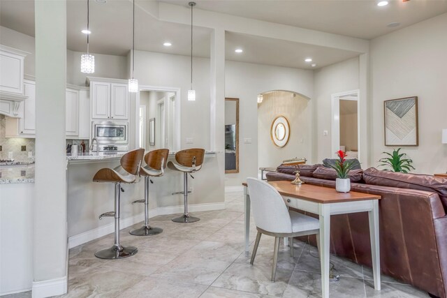 29114 Davenport Dr, Katy, TX 77494 - dining room featuring recessed lighting, arched walkways, and light marble finish floors