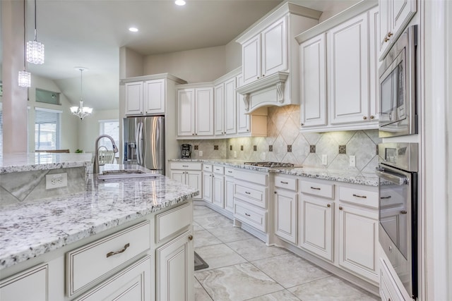 29114 Davenport Dr, Katy, TX 77494 - kitchen with appliances with stainless steel finishes, a chandelier, backsplash, white cabinets, and vaulted ceiling