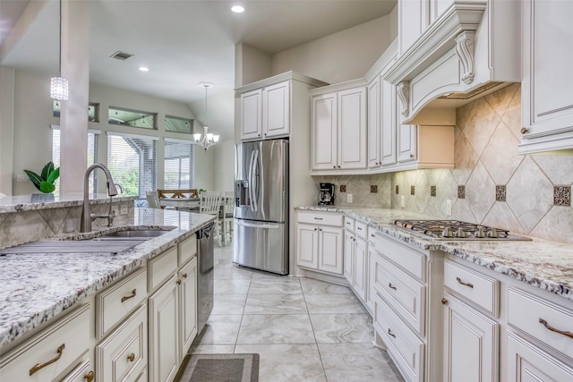 29114 Davenport Dr, Katy, TX 77494 - kitchen with appliances with stainless steel finishes, a chandelier, tasteful backsplash, light stone counters, and white cabinetry