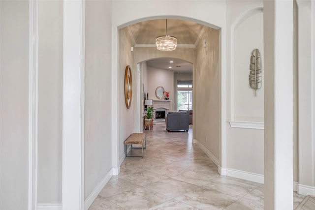 29114 Davenport Dr, Katy, TX 77494 - hall featuring ornamental molding, arched walkways, a chandelier, and light marble finish floors