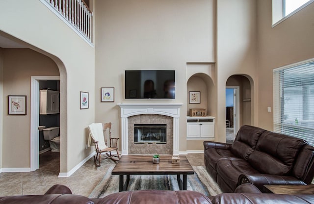 20303 Misty River Way, Cypress, TX 77433 - tiled living room with a high ceiling, a tiled fireplace, and arched walkways