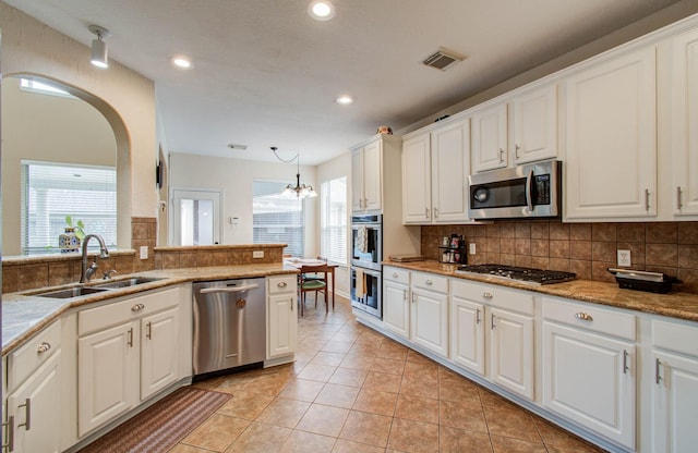 20303 Misty River Way, Cypress, TX 77433 - kitchen with appliances with stainless steel finishes, backsplash, recessed lighting, white cabinetry, and arched walkways