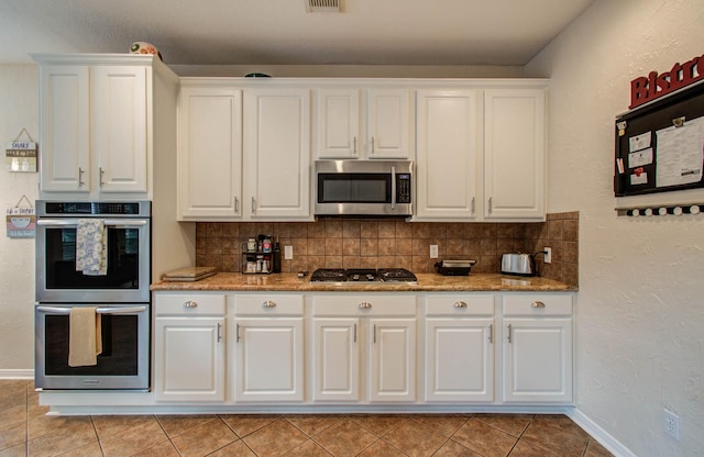 20303 Misty River Way, Cypress, TX 77433 - kitchen with stainless steel appliances, white cabinets, tasteful backsplash, and light tile patterned flooring