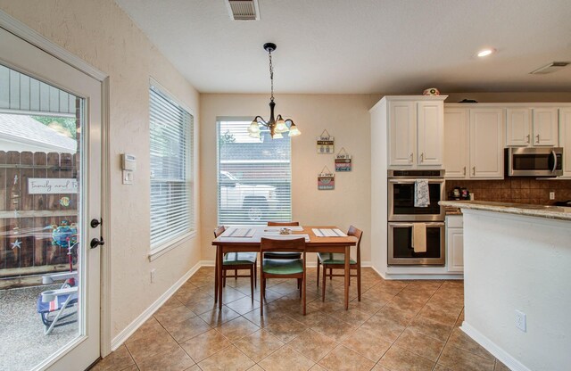 20303 Misty River Way, Cypress, TX 77433 - dining room featuring healthy amount of natural light, a chandelier, light tile patterned floors, and recessed lighting