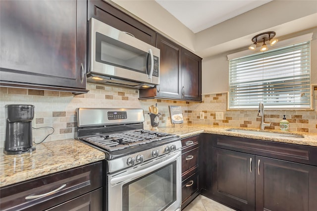 902 Grove Rd, Clear Lake Shores, TX 77565 - kitchen featuring appliances with stainless steel finishes, dark brown cabinets, light stone counters, and decorative backsplash