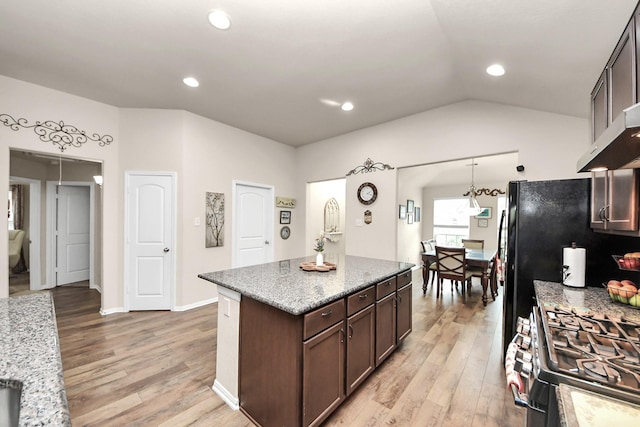 32726 Timber Point Dr, Brookshire, TX 77423 - kitchen with light wood-type flooring, dark brown cabinetry, light stone counters, a center island, and recessed lighting
