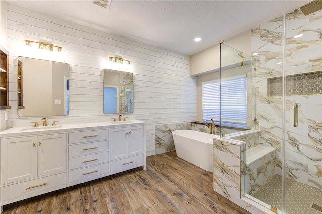18511 Yellowstone Trl, Humble, TX 77346 - full bath featuring wood finished floors, double vanity, a marble finish shower, a freestanding bath, and recessed lighting