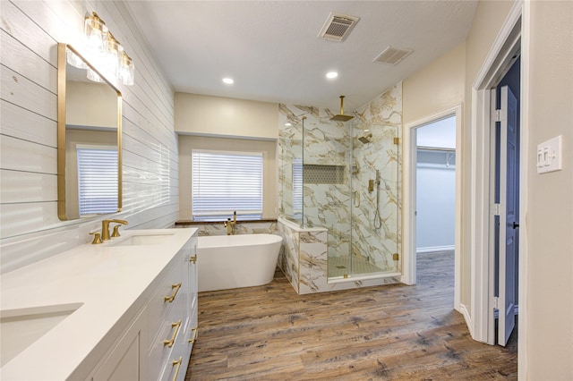 18511 Yellowstone Trl, Humble, TX 77346 - bathroom featuring a marble finish shower, double vanity, wood finished floors, a freestanding tub, and recessed lighting