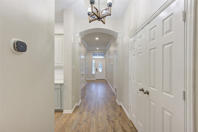 18511 Yellowstone Trl, Humble, TX 77346 - corridor with arched walkways, a chandelier, light wood-type flooring, and ornamental molding