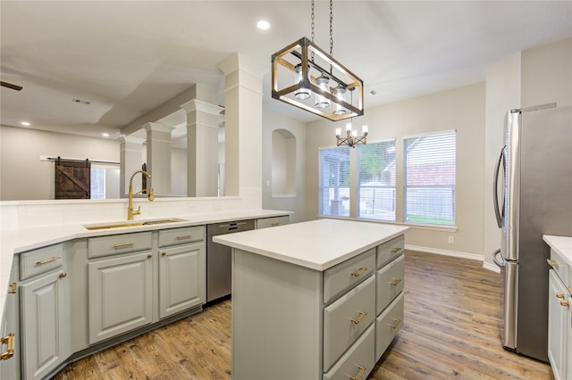 18511 Yellowstone Trl, Humble, TX 77346 - kitchen with stainless steel appliances, gray cabinets, a center island, light wood-style floors, and recessed lighting