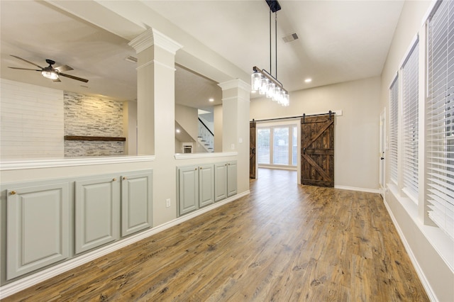 18511 Yellowstone Trl, Humble, TX 77346 - unfurnished dining area with ceiling fan, decorative columns, wood finished floors, a barn door, and recessed lighting