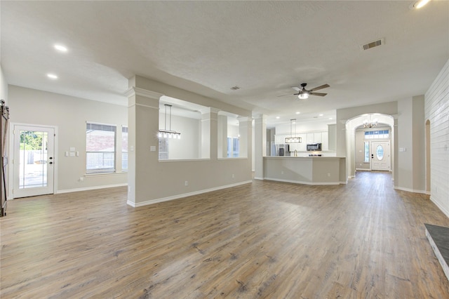 18511 Yellowstone Trl, Humble, TX 77346 - unfurnished living room with ceiling fan, light wood-style flooring, ornate columns, and recessed lighting