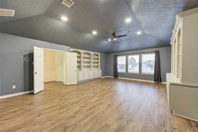 18511 Yellowstone Trl, Humble, TX 77346 - unfurnished living room featuring lofted ceiling, a textured ceiling, ceiling fan, wood finished floors, and built in shelves