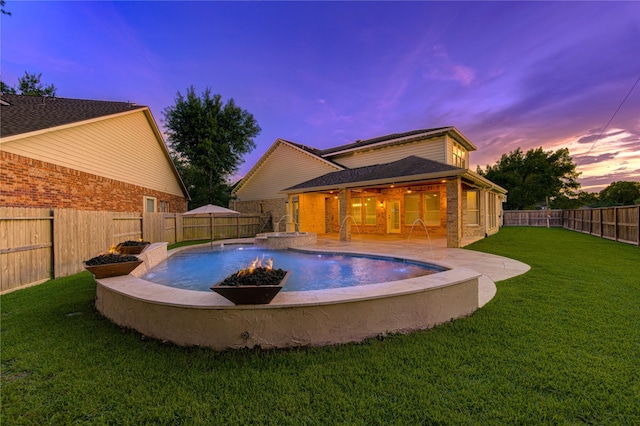18511 Yellowstone Trl, Humble, TX 77346 - pool at dusk with a patio, a fenced backyard, a fire pit, and a pool with connected hot tub
