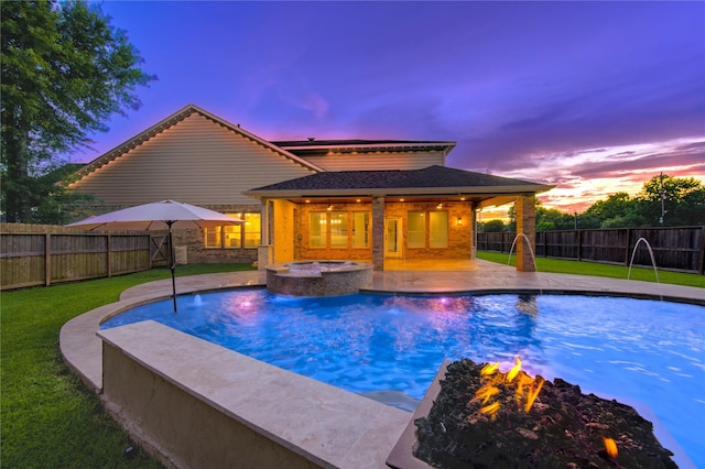 18511 Yellowstone Trl, Humble, TX 77346 - pool at dusk featuring a fire pit, an in-ground hot tub, a fenced backyard, and a patio area