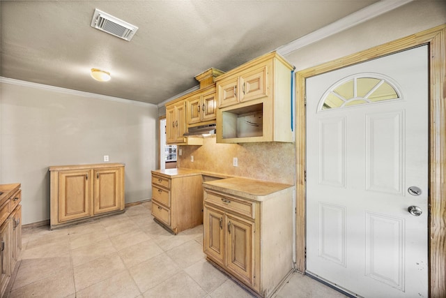 5419 Firefly Ave, Houston, TX 77017 - kitchen featuring crown molding, tasteful backsplash, light countertops, and under cabinet range hood