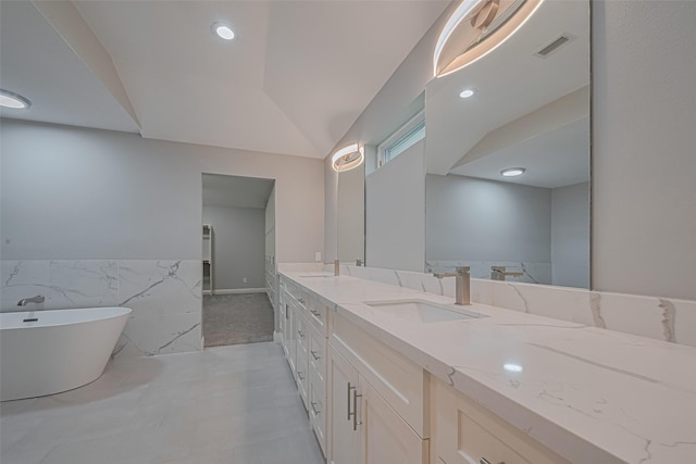 4414 Lemac Dr, Houston, TX 77096 - full bath featuring double vanity, a freestanding tub, tile walls, a wainscoted wall, and vaulted ceiling