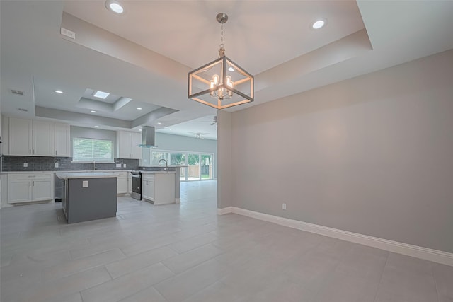4414 Lemac Dr, Houston, TX 77096 - kitchen with wall chimney exhaust hood, a raised ceiling, a chandelier, open floor plan, and tasteful backsplash