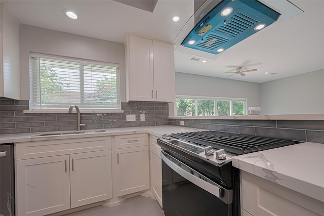 4414 Lemac Dr, Houston, TX 77096 - kitchen featuring appliances with stainless steel finishes, a ceiling fan, exhaust hood, light stone countertops, and white cabinetry