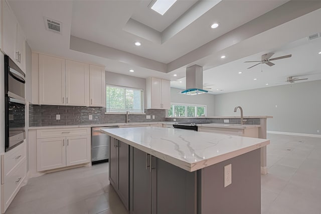 4414 Lemac Dr, Houston, TX 77096 - kitchen with stainless steel appliances, island exhaust hood, a center island, tasteful backsplash, and recessed lighting