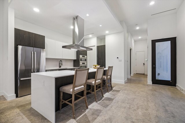 2014 Colquitt, Houston, TX 77098 - kitchen with island exhaust hood, appliances with stainless steel finishes, modern cabinets, light countertops, and a kitchen island