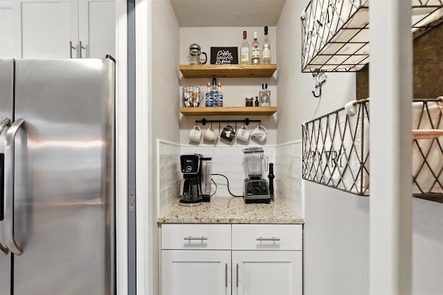 79 Fallshire Dr, The Woodlands, TX 77381 - indoor dry bar featuring freestanding refrigerator and decorative backsplash