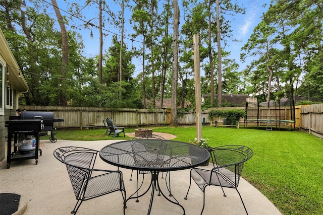 79 Fallshire Dr, The Woodlands, TX 77381 - fenced backyard with a trampoline, a patio, outdoor dining space, and grilling area