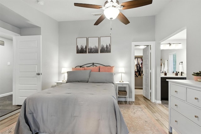 79 Fallshire Dr, The Woodlands, TX 77381 - bedroom with light wood-style floors, a spacious closet, connected bathroom, and ceiling fan