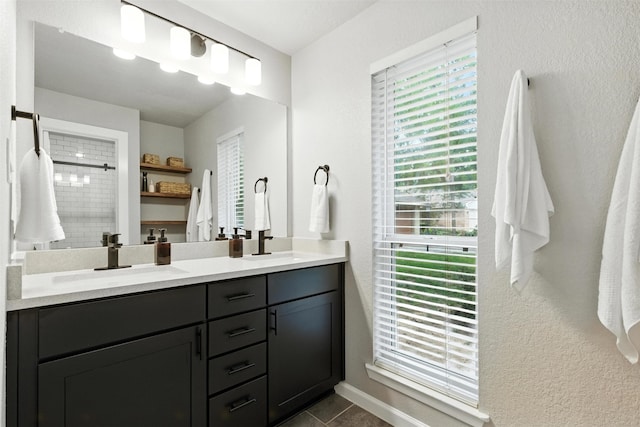 79 Fallshire Dr, The Woodlands, TX 77381 - full bathroom with double vanity, a tile shower, tile patterned floors, and a textured wall