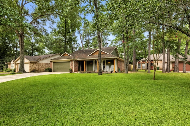 79 Fallshire Dr, The Woodlands, TX 77381 - view of front of property with covered porch, concrete driveway, a garage, a front yard, and brick siding