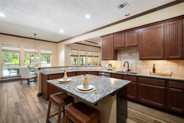 11399 Fm-3126, Livingston, TX 77351 - kitchen with a textured ceiling, a peninsula, a center island, ornamental molding, and light stone countertops