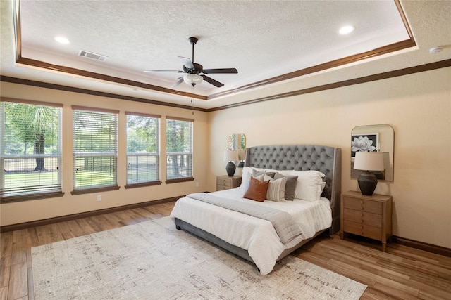 11399 Fm-3126, Livingston, TX 77351 - bedroom with a tray ceiling, ornamental molding, wood finished floors, a textured ceiling, and a ceiling fan