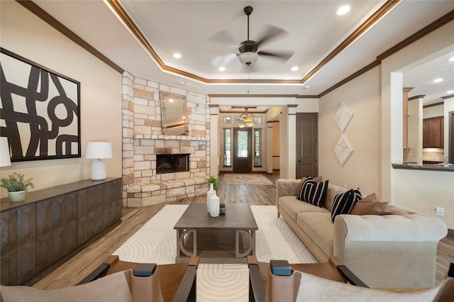 11399 Fm-3126, Livingston, TX 77351 - living area with a raised ceiling, wood finished floors, crown molding, ceiling fan, and a stone fireplace