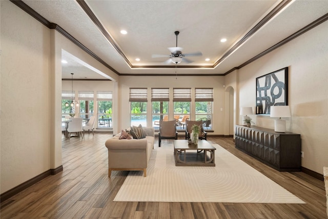 11399 Fm-3126, Livingston, TX 77351 - living area featuring ceiling fan, ornamental molding, arched walkways, wood finished floors, and a tray ceiling