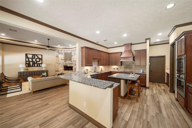 11399 Fm-3126, Livingston, TX 77351 - kitchen featuring custom range hood, appliances with stainless steel finishes, ornamental molding, a breakfast bar, and a textured ceiling