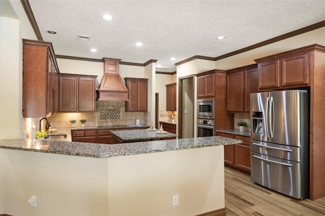 11399 Fm-3126, Livingston, TX 77351 - kitchen featuring appliances with stainless steel finishes, premium range hood, stone countertops, light wood finished floors, and a textured ceiling