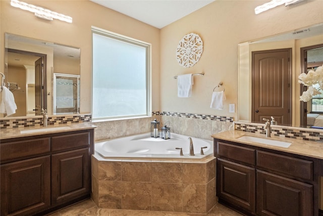 11399 Fm-3126, Livingston, TX 77351 - full bathroom featuring two vanities, a bath, and decorative backsplash