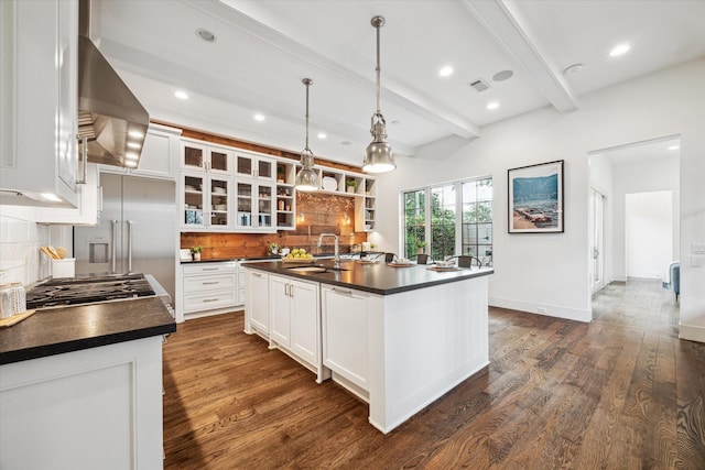 523 E 23rd St, Houston, TX 77008 - kitchen with dark countertops, backsplash, beam ceiling, wall chimney range hood, and white cabinetry