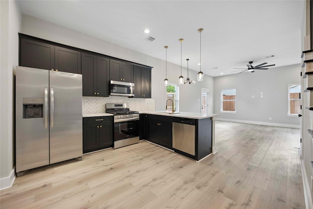 217 Pheasant St, Houston, TX 77018 - kitchen featuring stainless steel appliances, a ceiling fan, tasteful backsplash, light wood finished floors, and light countertops