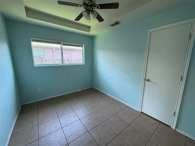 5518 Rio Ramos St, Rosharon, TX 77583 - empty room featuring a ceiling fan, a tray ceiling, and tile patterned flooring