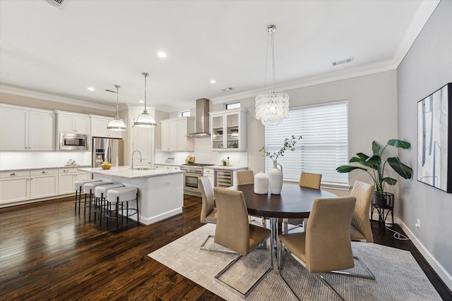 521 W Bell St, Houston, TX 77019 - dining area with crown molding, dark wood finished floors, a chandelier, recessed lighting, and beverage cooler