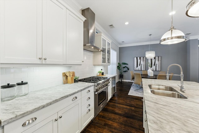 521 W Bell St, Houston, TX 77019 - kitchen with wall chimney exhaust hood, high end stainless steel range oven, ornamental molding, dark wood-style flooring, and white cabinetry