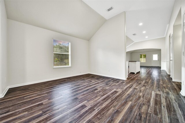 11703 Elizabeth Ct, Pinehurst, TX 77362 - unfurnished living room with dark wood-style flooring, arched walkways, and lofted ceiling