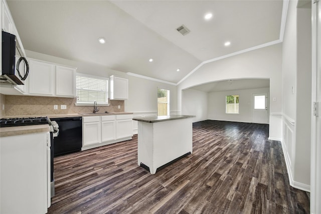 11703 Elizabeth Ct, Pinehurst, TX 77362 - kitchen featuring stainless steel microwave, dishwasher, vaulted ceiling, dark wood finished floors, and healthy amount of natural light